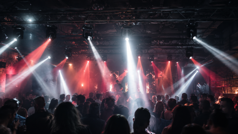 Moving head beam lights for nightclubs above a DJ dance floor