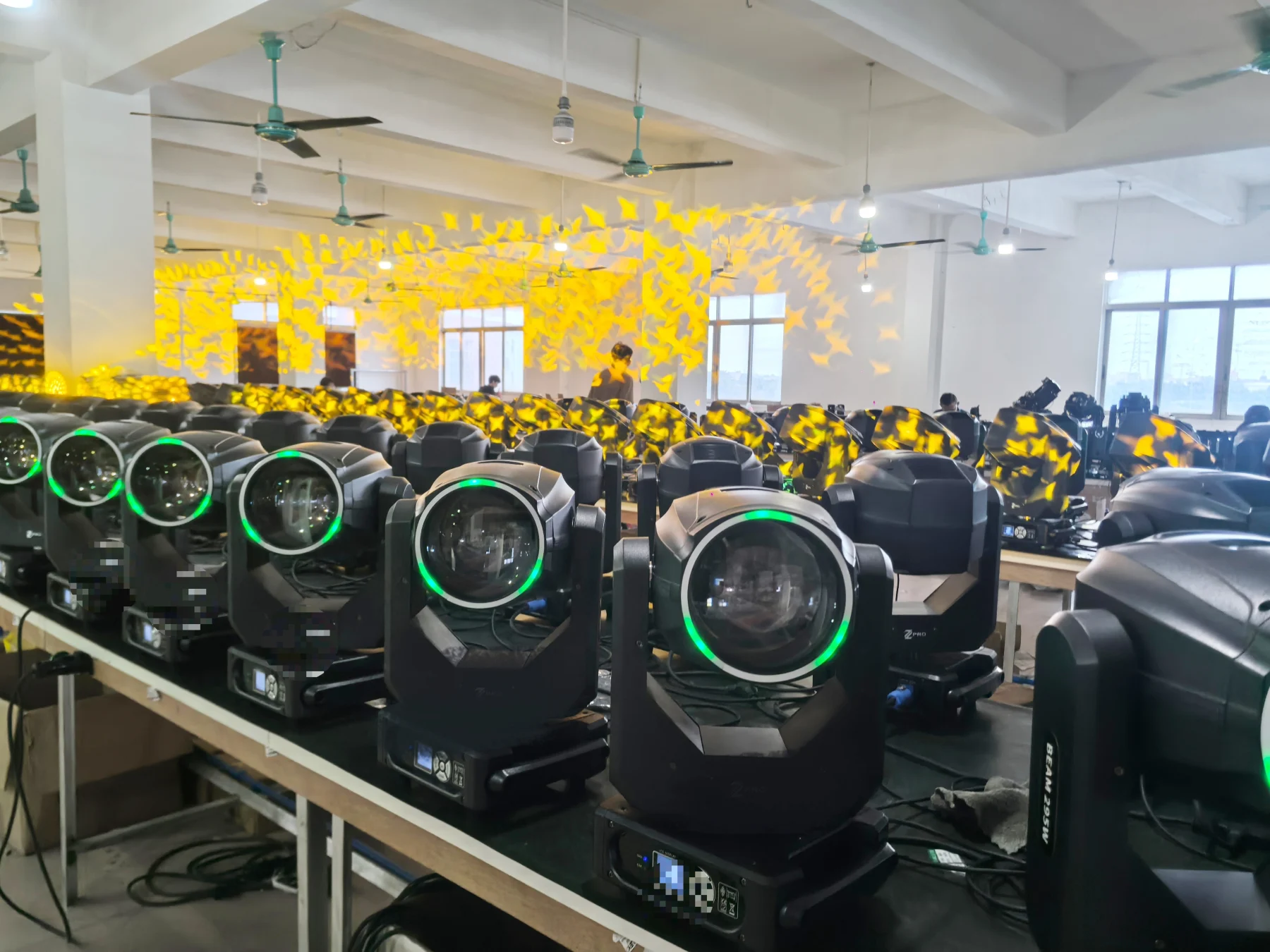 Beam moving head fixtures projecting gobo effects during workshop checks
