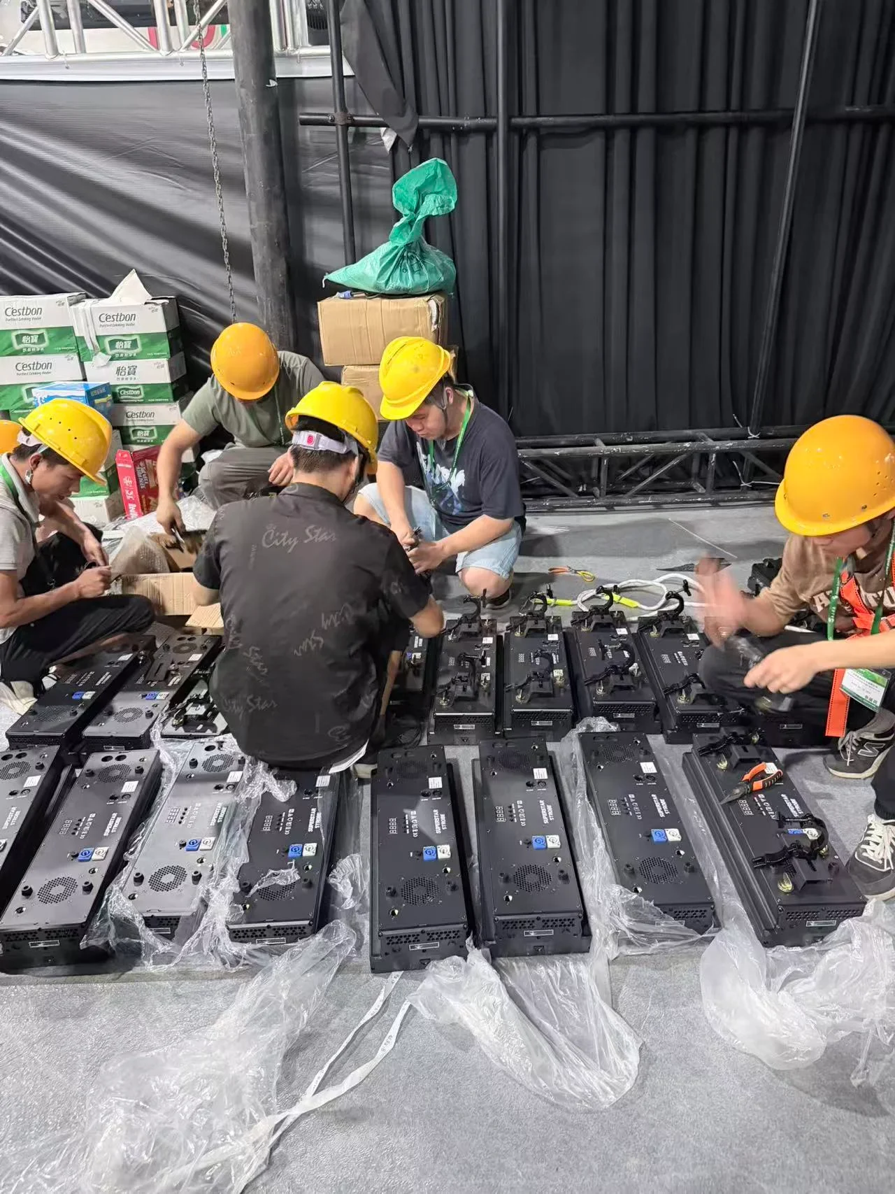 Person working on stage-lighting equipment at a workbench.
