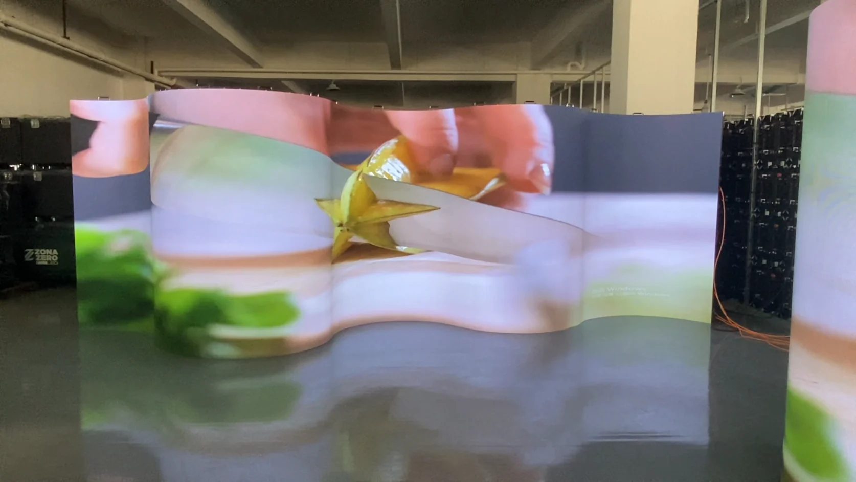 Indoor Flexible Curved LED Screen — Curved indoor LED screen wall showing fruit content across a continuous wave surface