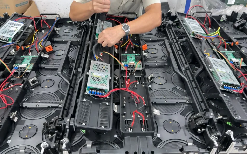 Technicien intervenant sur des cabinets LED ouverts avec câblage visible