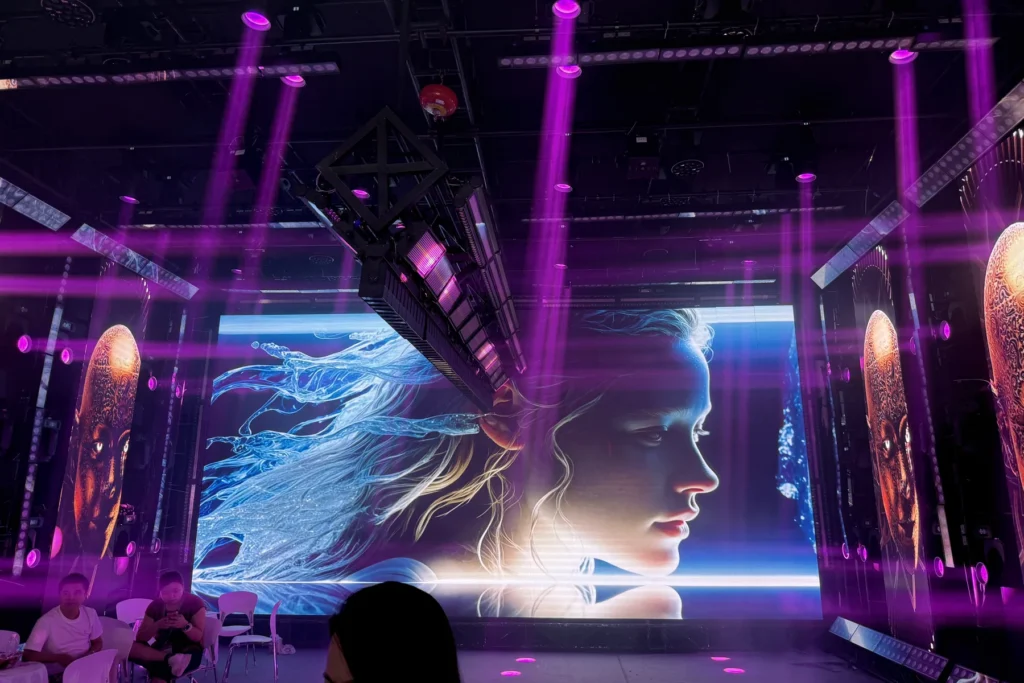 Large LED portrait display with overhead stage lighting at the WUYESTAGE Guangzhou exhibition