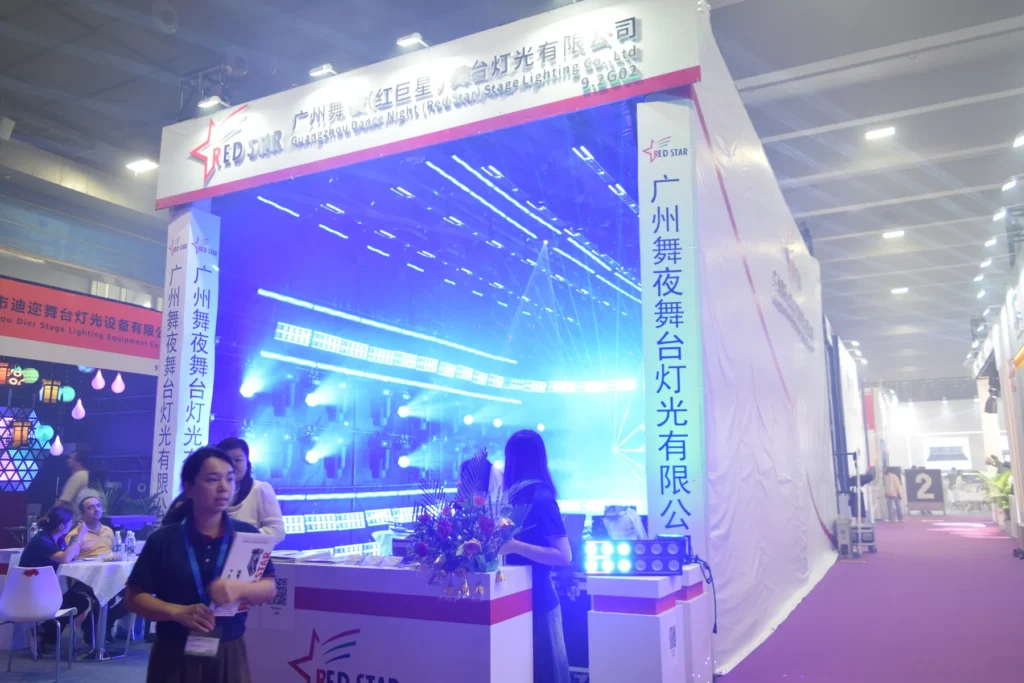 Illuminated WUYESTAGE exhibition booth entrance with visitors