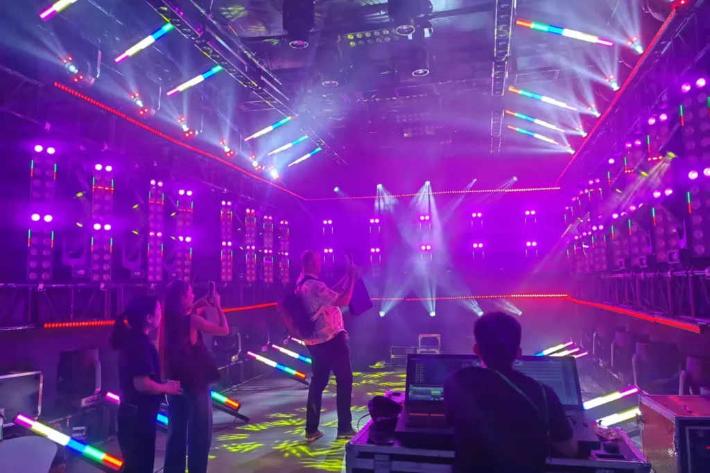 Colorful stage lighting beam demonstration at a WUYESTAGE exhibition