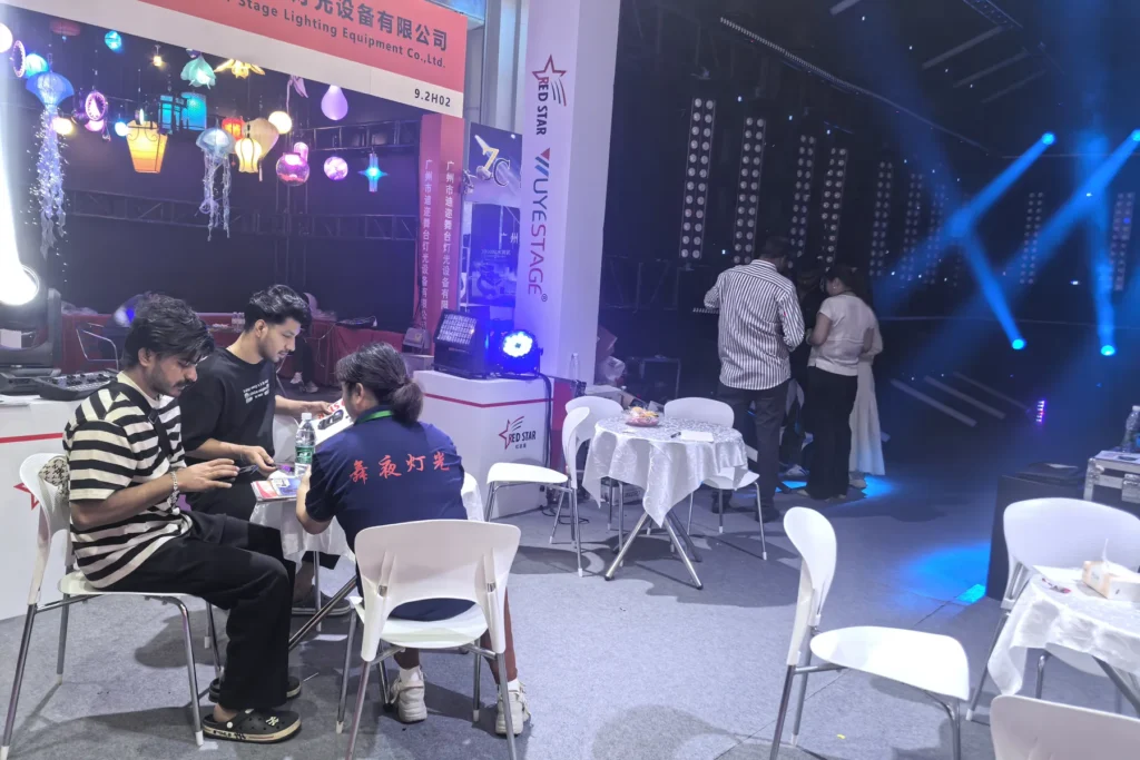 Visitors meeting inside a WUYESTAGE exhibition booth with LED display backdrop