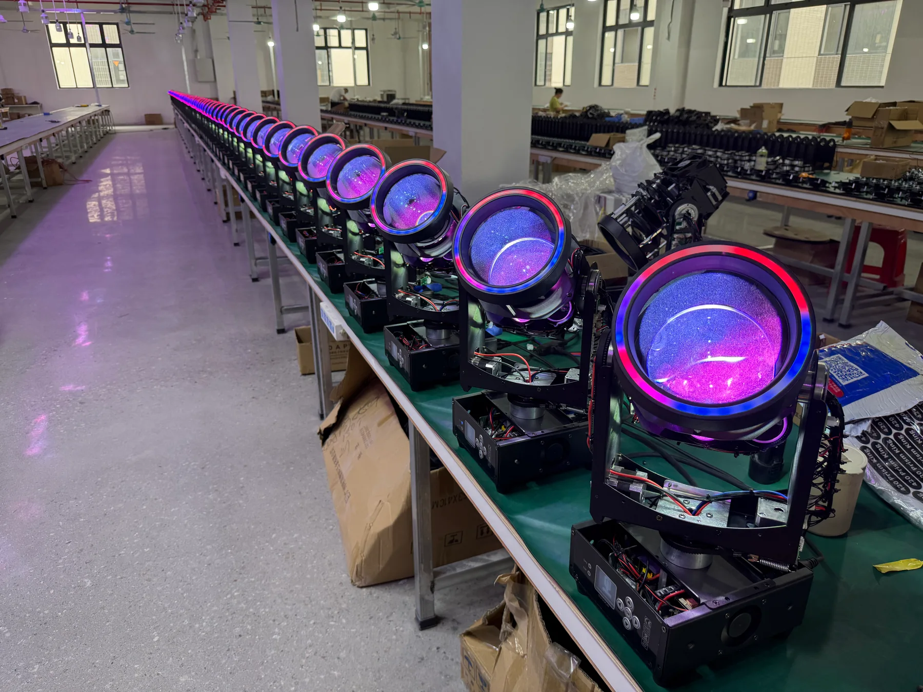 Beam moving head fixtures with purple lens rings on the workshop assembly line