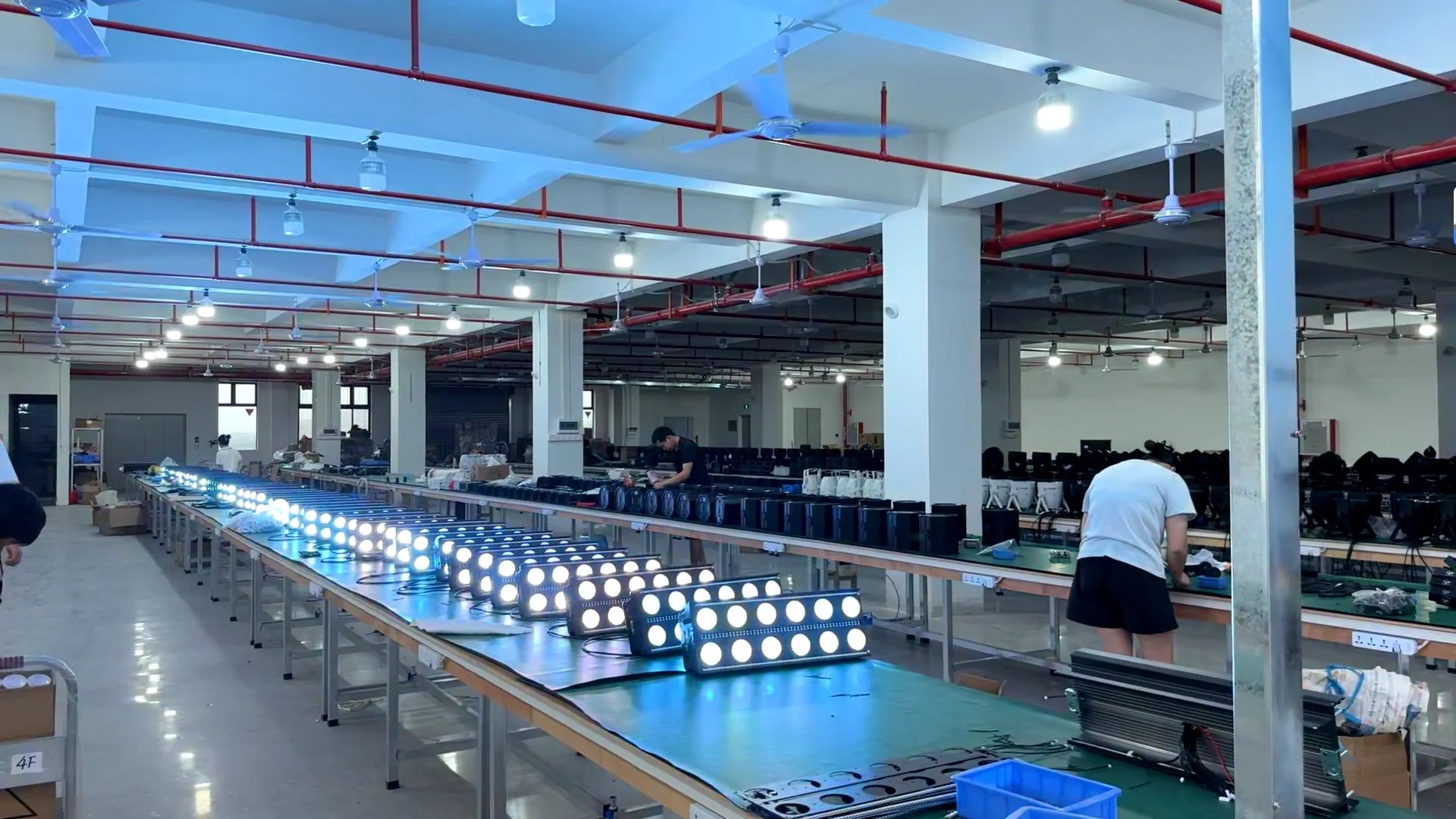 Wide workshop production line with RGBW stage effect lights under blue output checks
