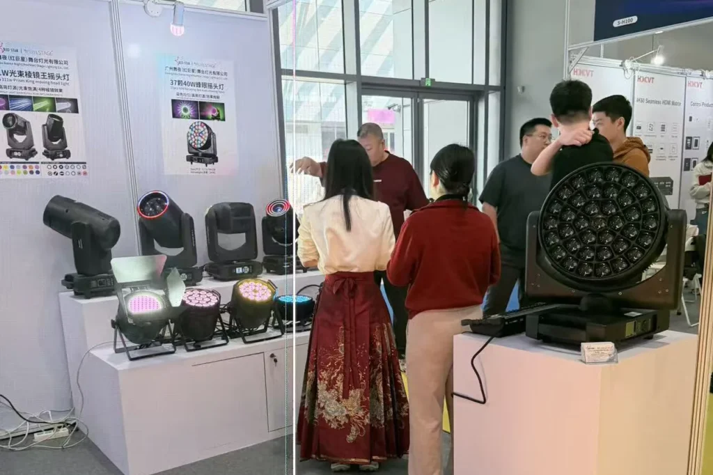 Visitors discussing moving head lights at the WUYESTAGE Shenzhen exhibition booth