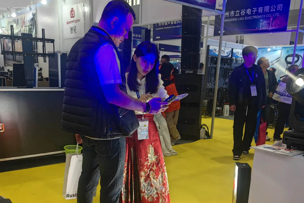 Exhibition visitors examining stage lighting equipment at the WUYESTAGE Shenzhen booth