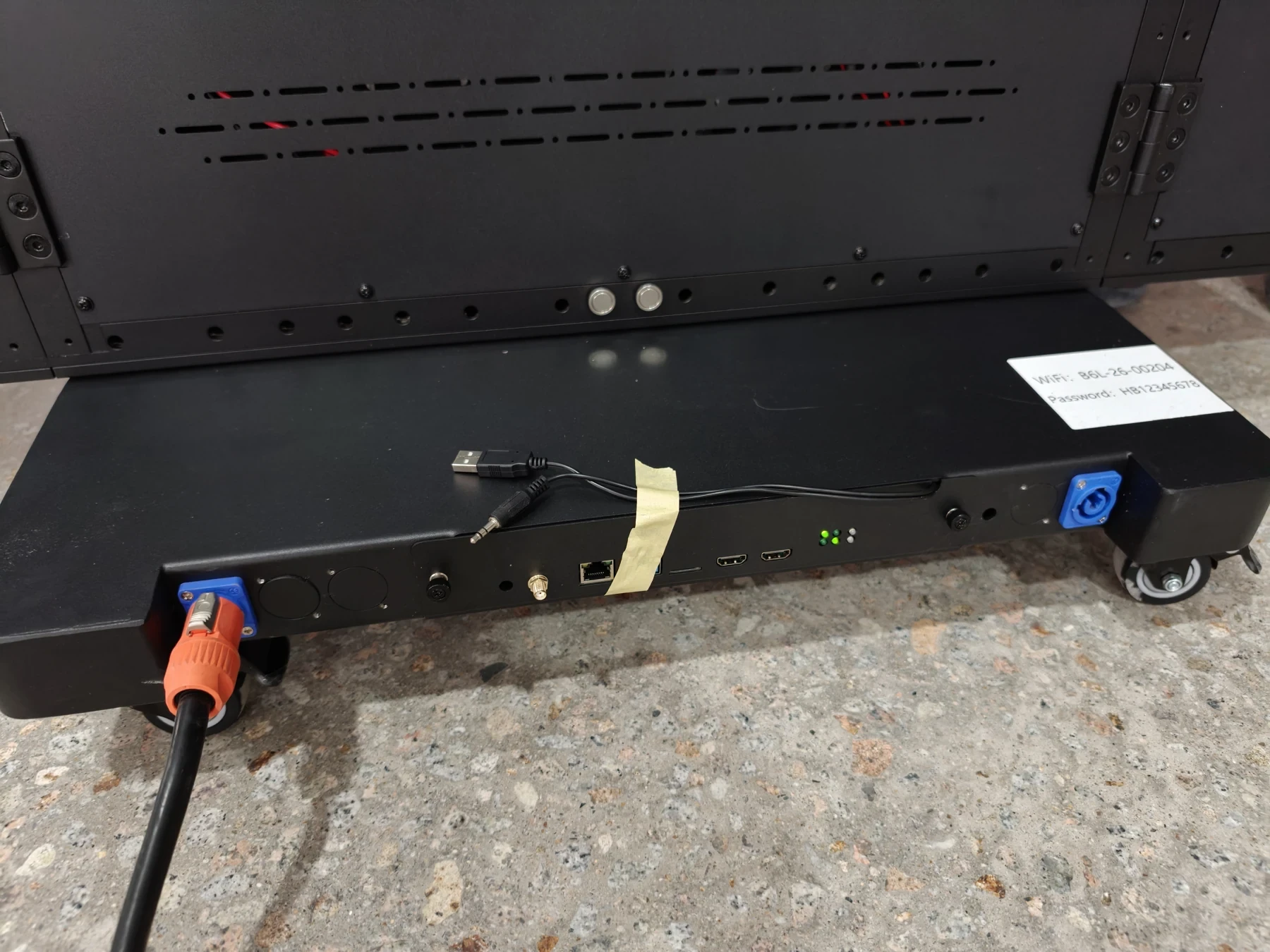 Close view of the display base with visible connection points and caster wheels