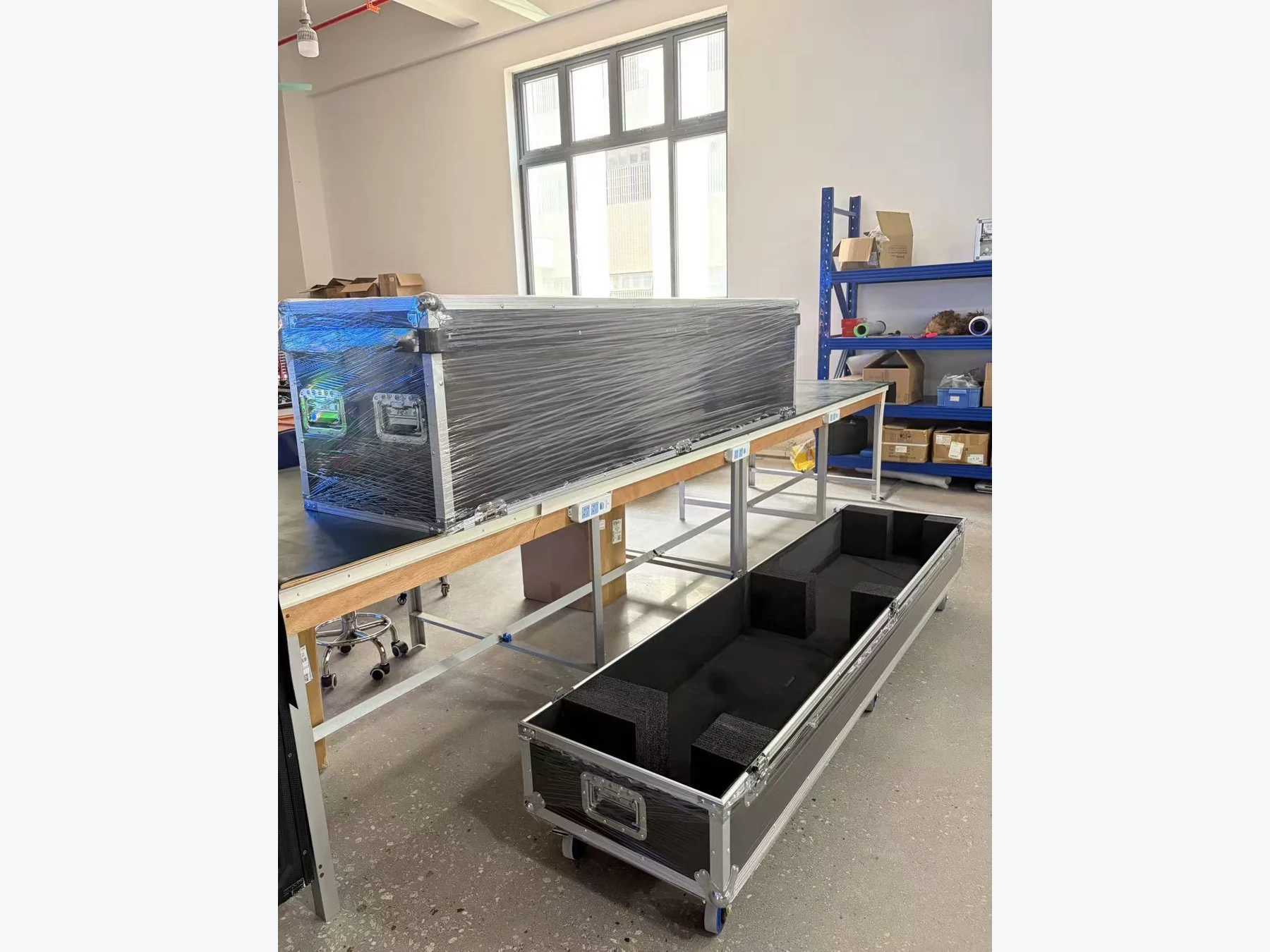Flight case with a divided foam interior beside wrapped equipment