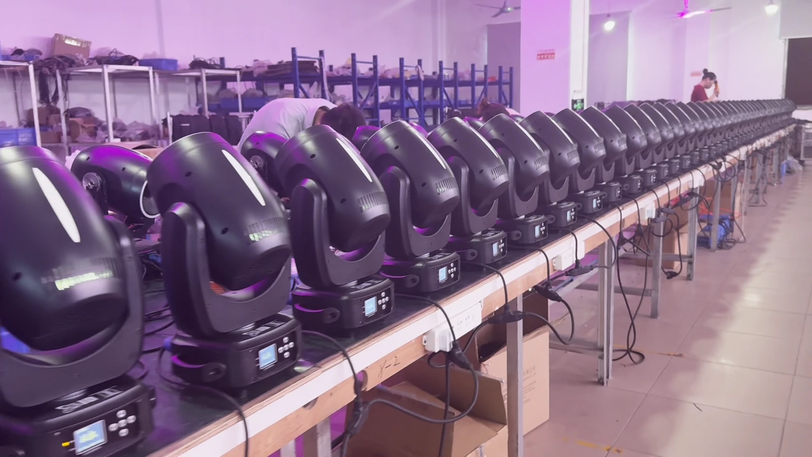Rows of moving heads at a workshop bench, viewed from the rear
