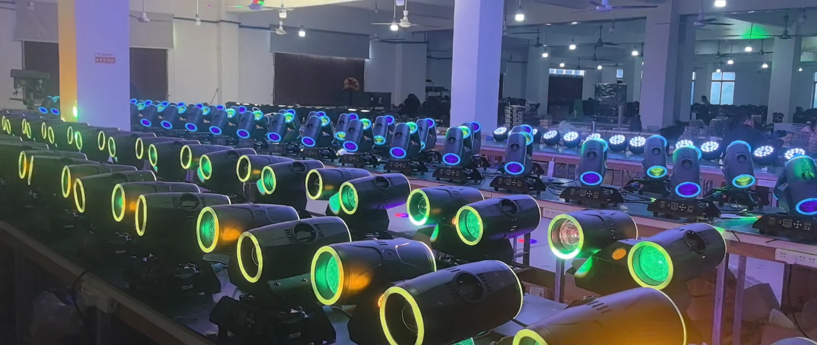 Workshop rows of powered-on twin-head fixtures viewed across the front of the benches