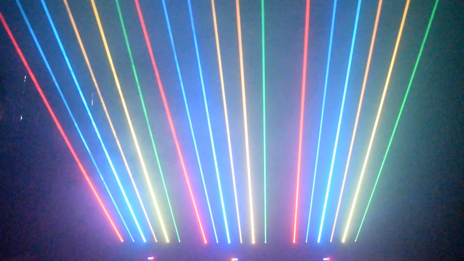 Multiple RGB laser bars producing multicolored upward beams in a demonstration