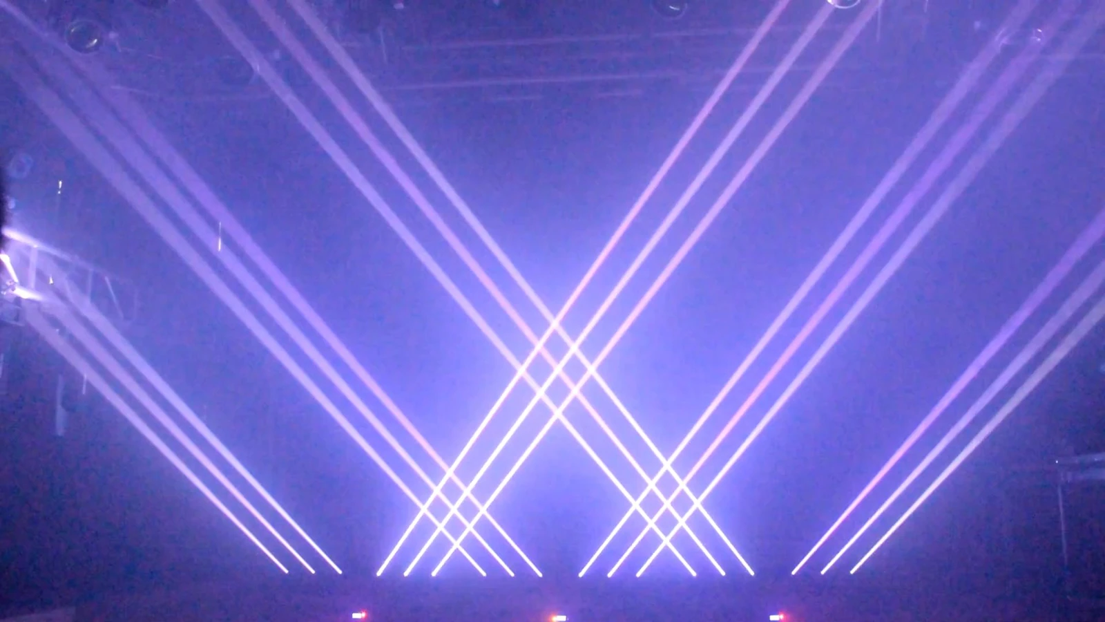 Multiple RGB laser bars producing pale crossing beams in a demonstration