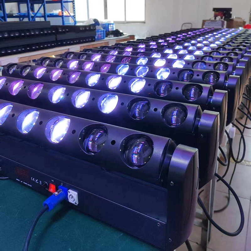 Rows of linear beam fixtures powered on with blue and purple light at workshop benches